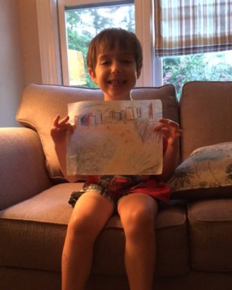 Second-grader Max Kander holds up a picture he drew of Tel Aviv.