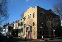 Photo of a brick synagogue building on a street corner against a clear blue sky.