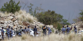 Photo of police officers searching citizens in South Africa.