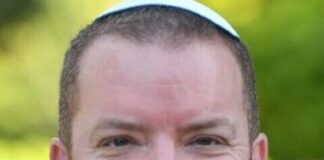 Photo of a man with a buzz cut wearing a white yarmulke.