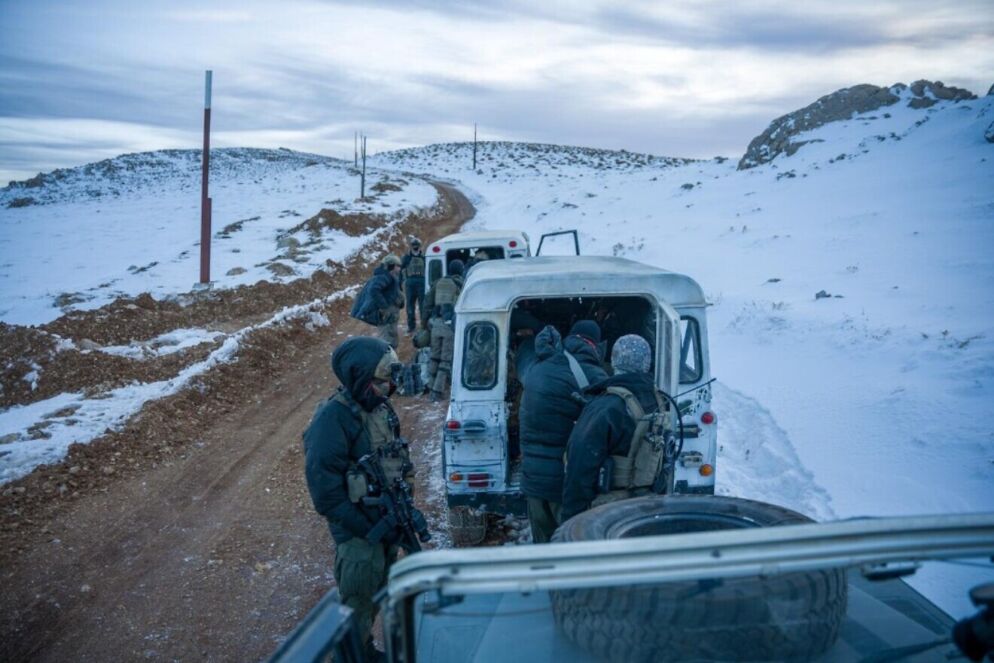 Photo of an Israeli Air Force troop on a road bordered by snow-covered grounds.