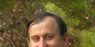 Headshot of a man in a suit and checkered tie.