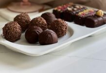 ‘Why on This Night Do We Dip in Chocolate?’ Stock photo of chocolate truffles on a plate in front of a wine glass.