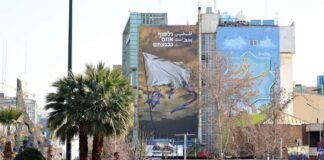 People walking past a billboard.