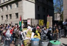 Columbia’s Unsettling Settlement Photo of college students protesting with signs and Palestinian flags.