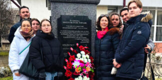 A group of people standing next to a stone monument.