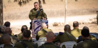 A soldier speaking to a group of other soldiers.