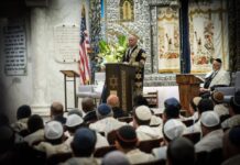 A man standing at a podium and addressing a congregation.