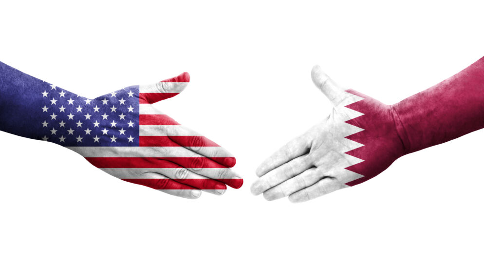 Handshake between Qatar and USA flags painted on hands, isolated transparent image.