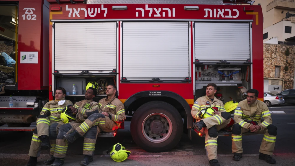 Emergency responders sitting in front of a red truck.