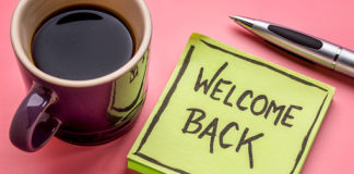 welcome back - handwriting on a sticky note with a cup of coffee