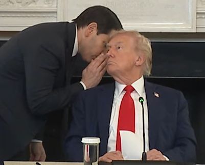 Photo of a man whispering in another man's ear.